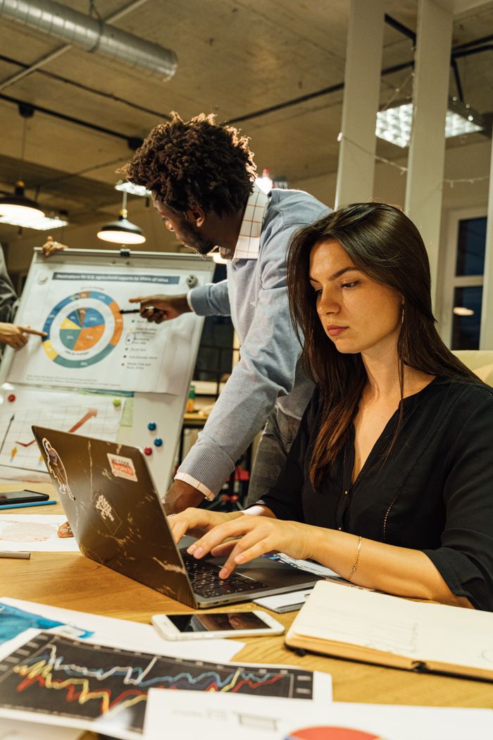Focused business team discussing reports and charts in a modern office environment.